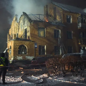 Einsatzkräfte löschen ein durch einen russischen Angriff getroffenes Wohnhaus.