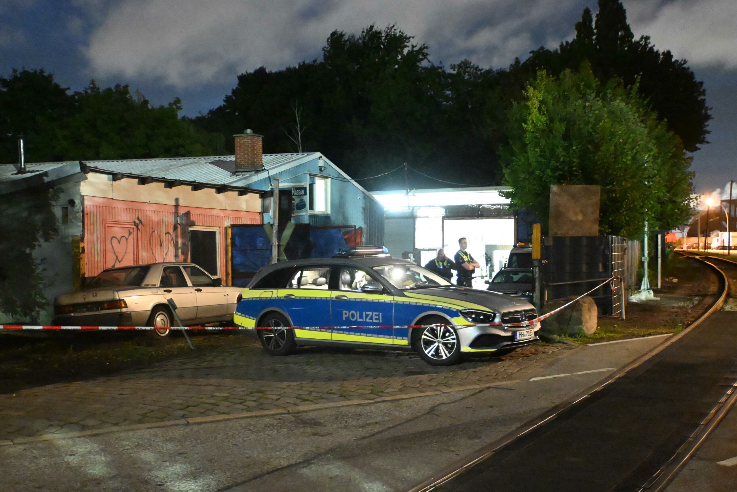 Einsatzkräfte der Polizei stehen auf einem Gewerbehof auf der Veddel.