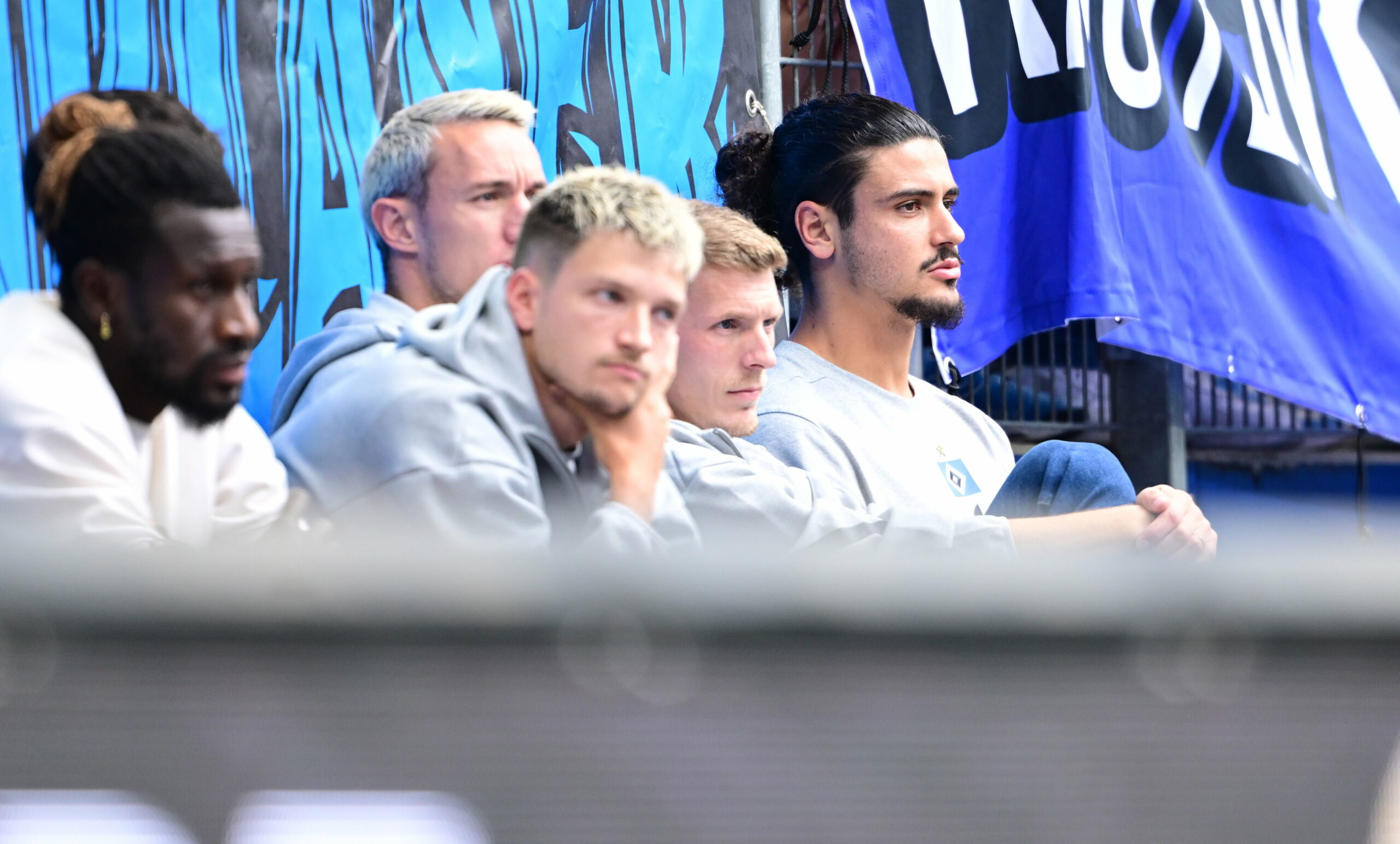 Noah Katterbach, Silvan Hefti, Emir Sahiti und Gui Ramos sitzen im Volksparkstadion auf der Tribüne.