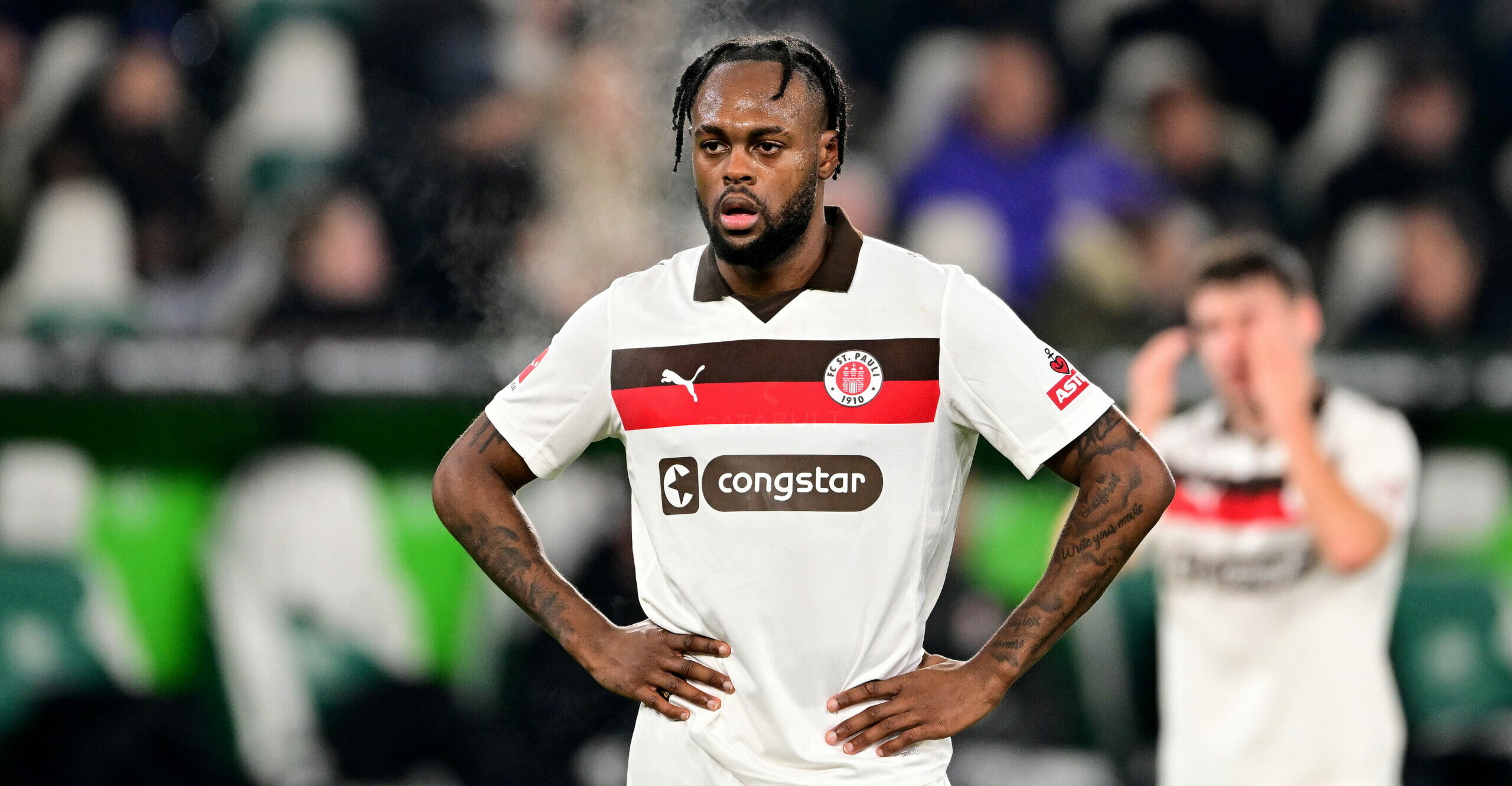 St. Pauli-Stürmer Ricky-Jade Jones hat beide Hände in die Hüften gestemmt