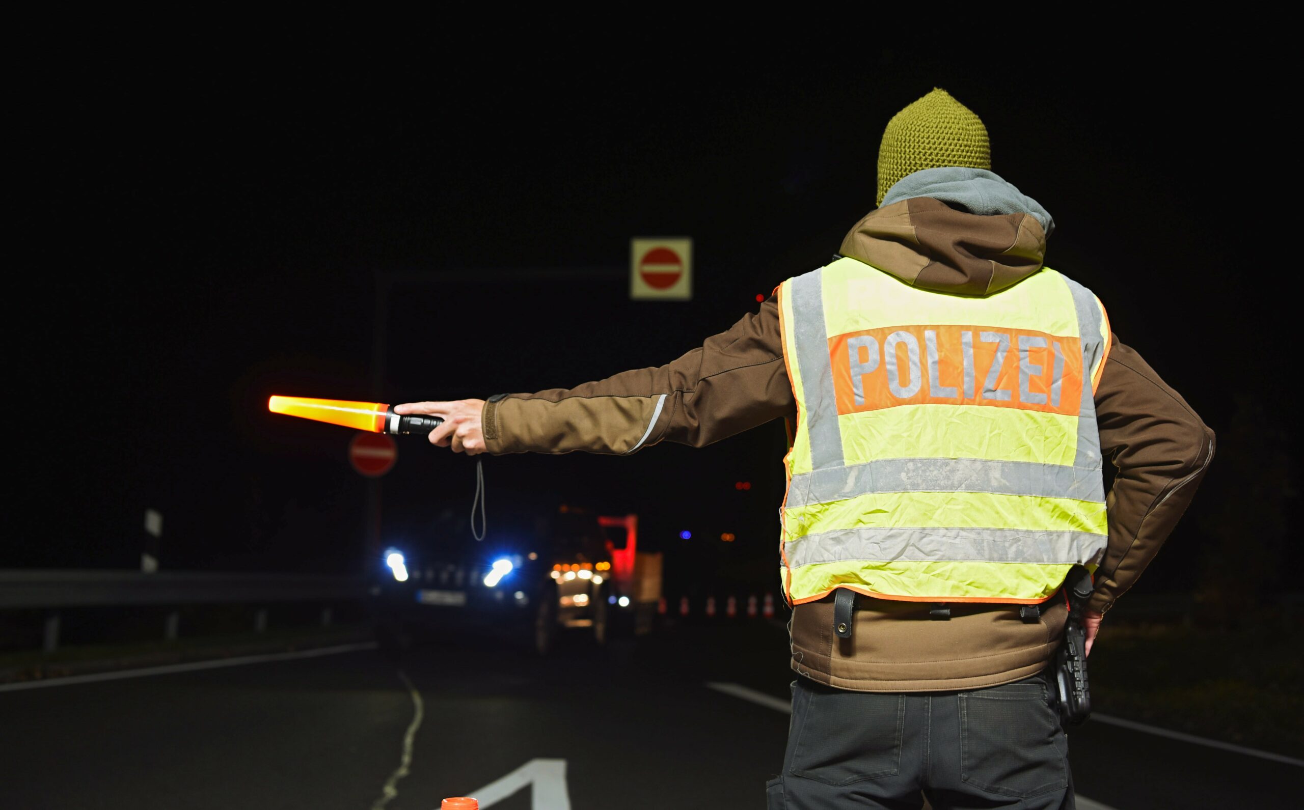 Ein Polizist leitet an einer Kontrollstelle der Polizei an einer Autobahn die Autos um (Symbolfoto).