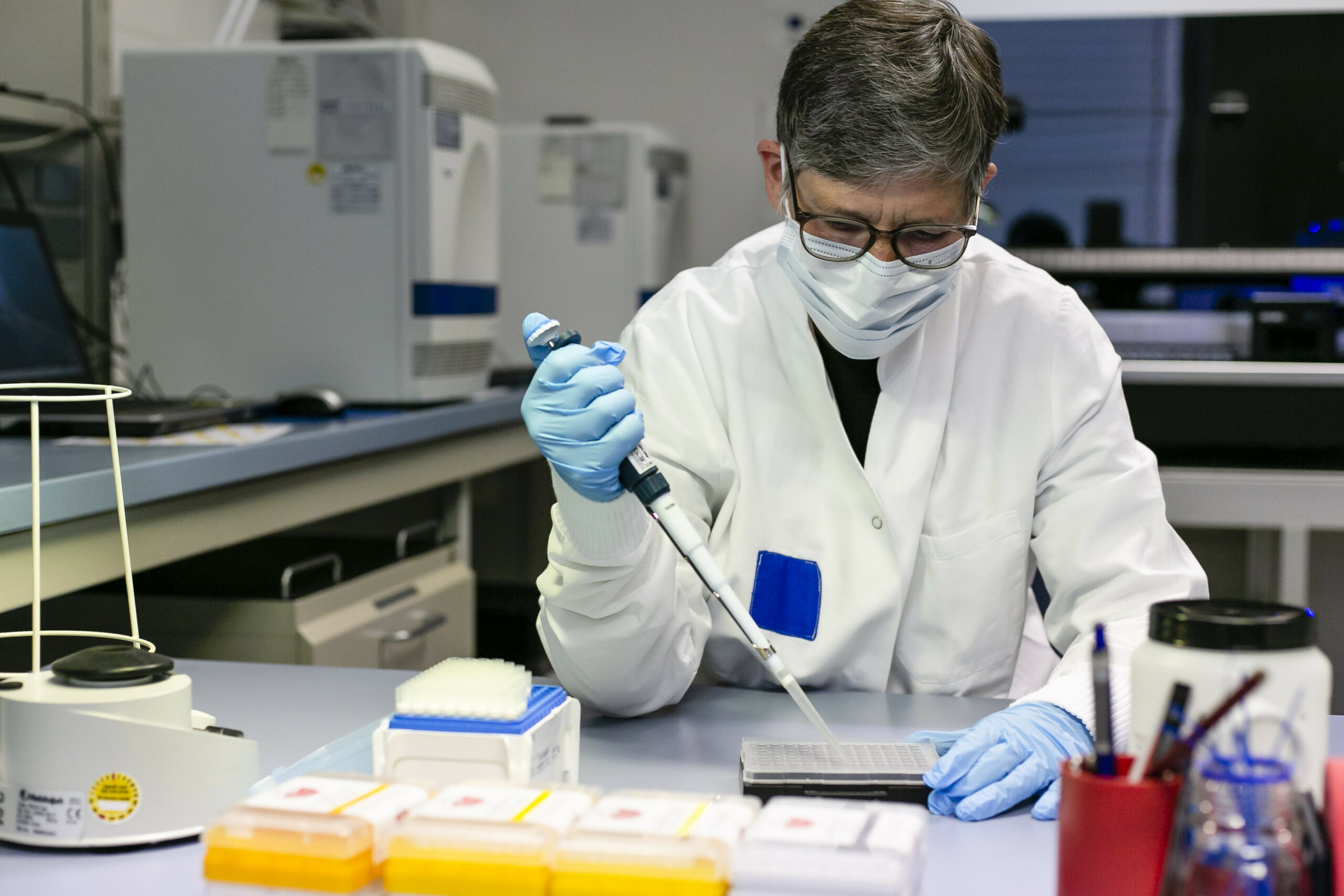 Eine Biochemikerin beim Landeskriminalamt in Kiel füllt mit einer Pipette Flüssigkeit in ein Behältnis.