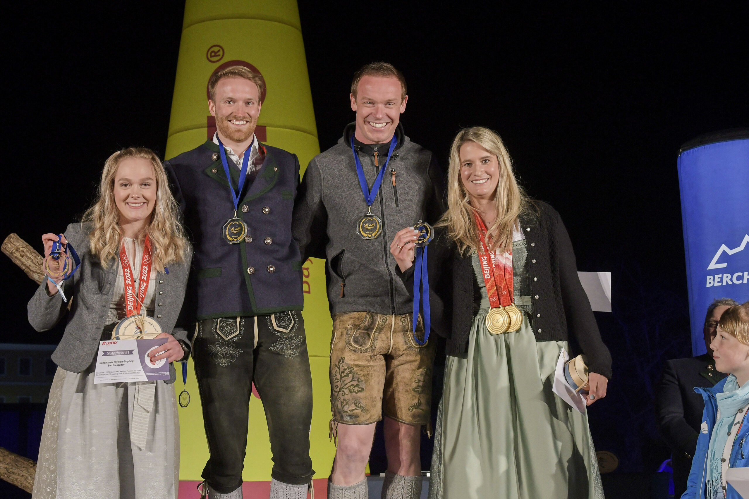 Felix Loch und Natalie Geisenberger posieren mit Medaillen auf einem Podium
