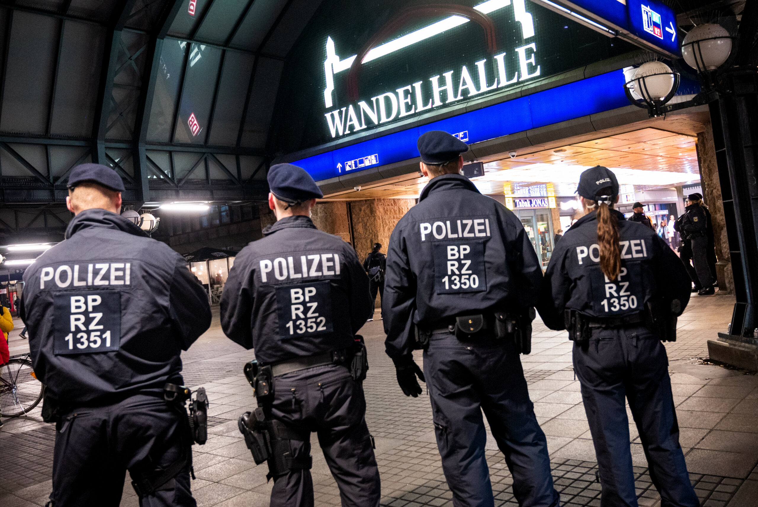 Einsatzkräfte der Bundespolizei stehen für ein Foto vor dem Hauptbahnhof mit der Wandelhalle zusammen.