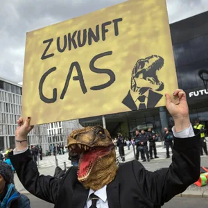 Ironisch-sarkastischer Protest gegen eine fossile Zukunft: ein Demonstrant als Dino verkleidet in Berlin.
