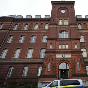 Ein Polizeifahrzeug steht vor dem Landgericht Flensburg.
