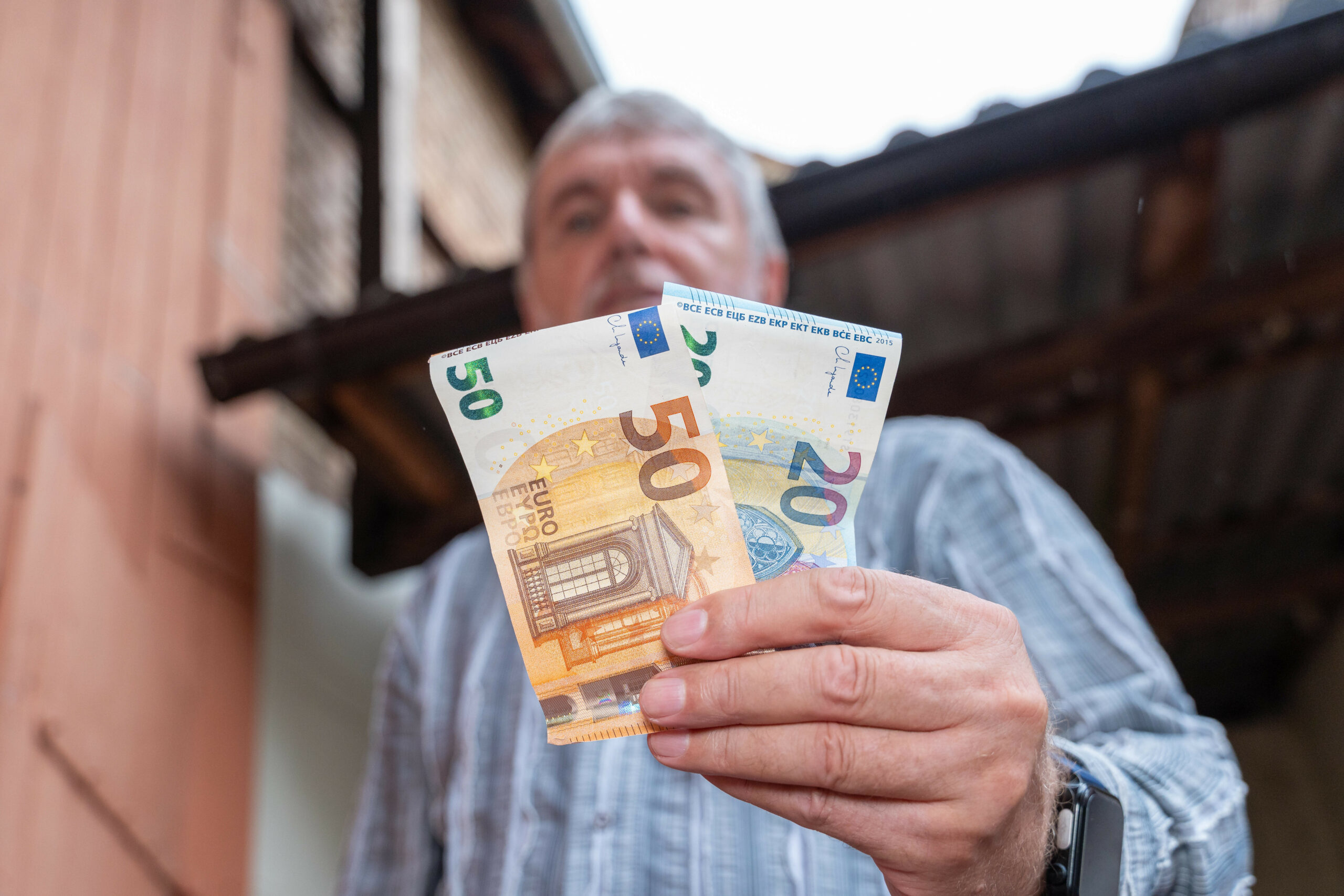 Ein Mann hält Geldscheine in der Hand. Fast jeder dritte Hamburger hat einer Umfrage nach Angst davor, sozial abzusteigen. (Symbolbild)
