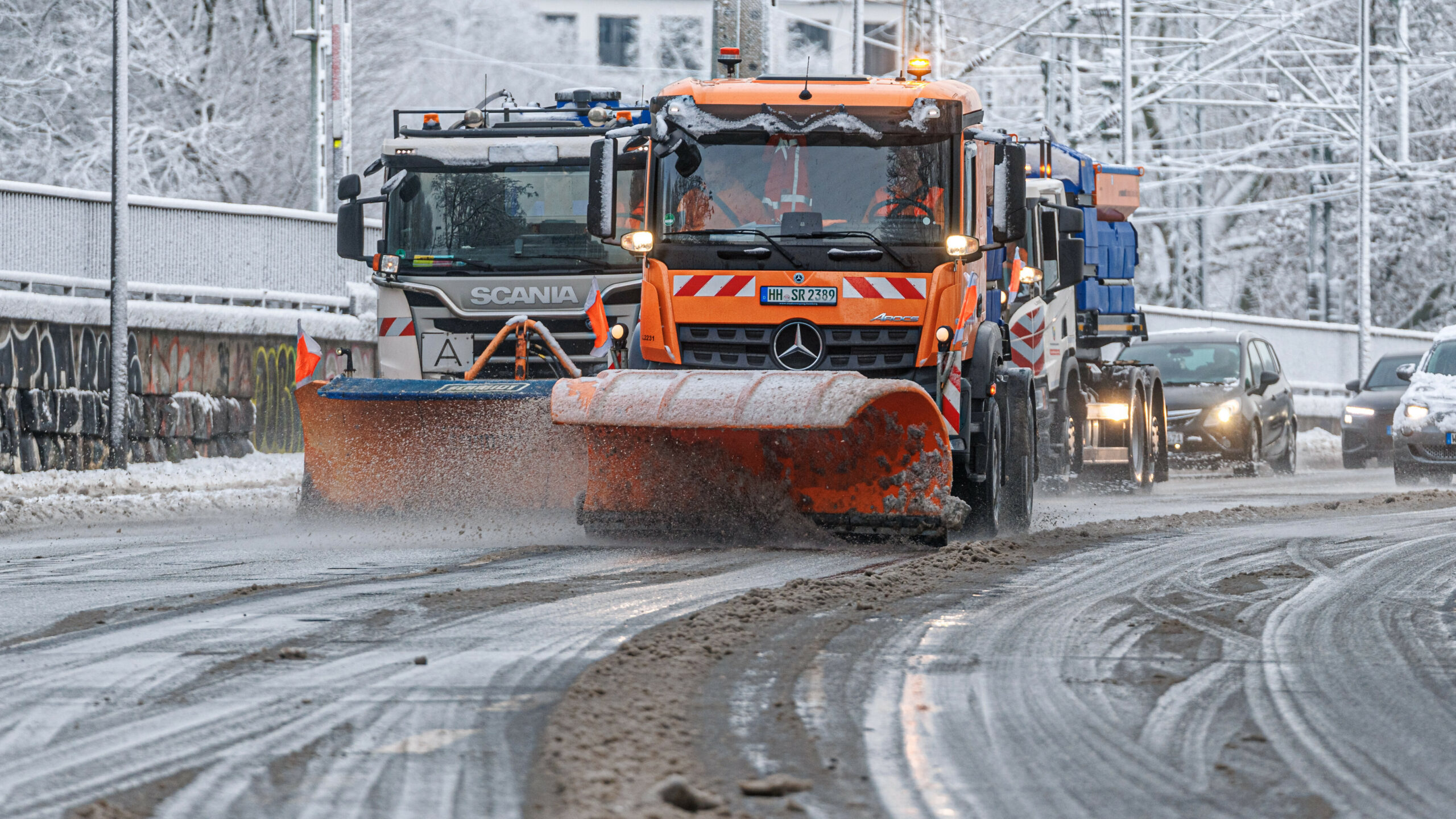 Fahrzeuge des Winterdienstes räumen den Schnee auf der Lombardsbrücke und streuen die Fahrbahn.