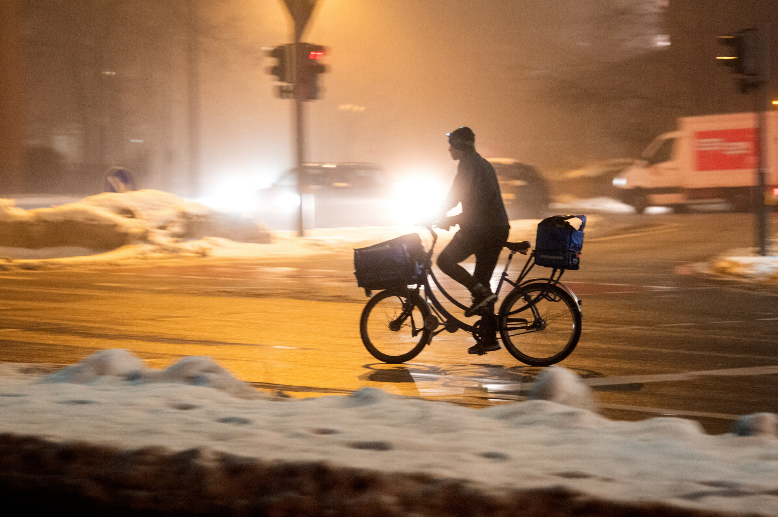 Ein Mann fährt am Morgen im Nebel und bei Tauwetter über eine Straße.