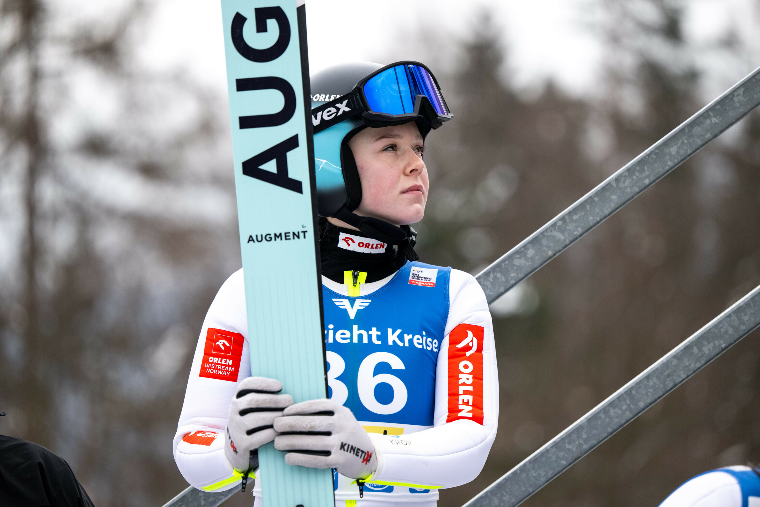 Pola Beltowska hält ihre Skier fest und schaut zur Seite