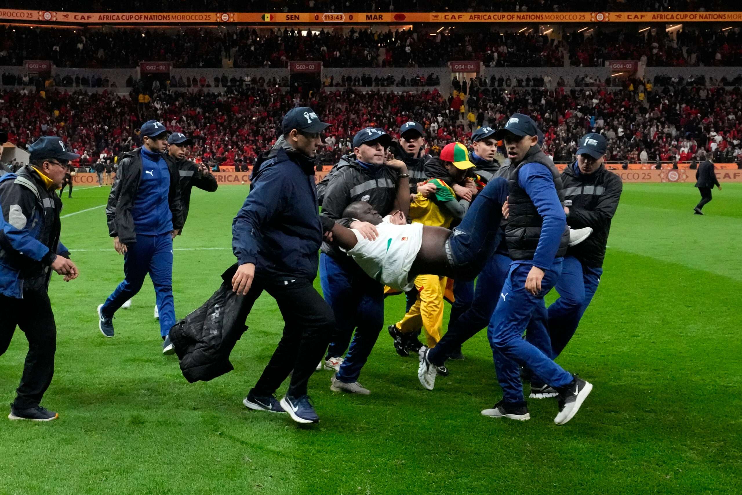 Sicherheitsbeamte tragen im Finale des Afrika-Cup einen Fan vom Platz