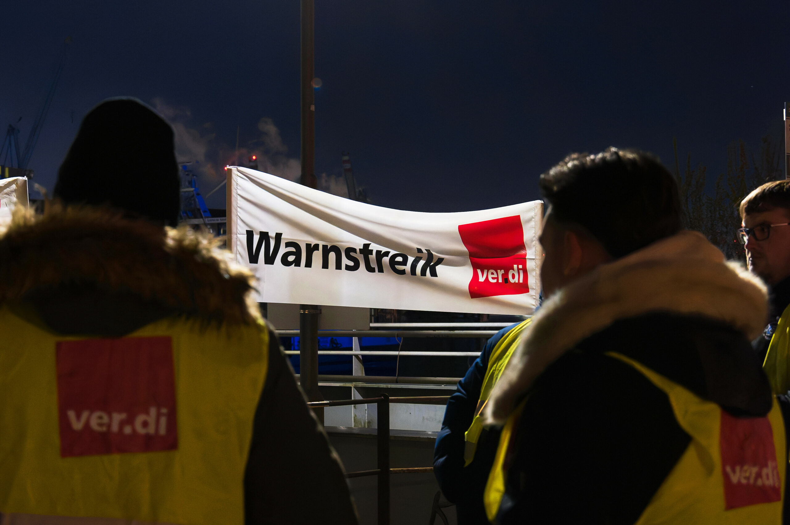 Teilnehmer stehen bei einem Verdi-Warnstreik an einem Streikposten.