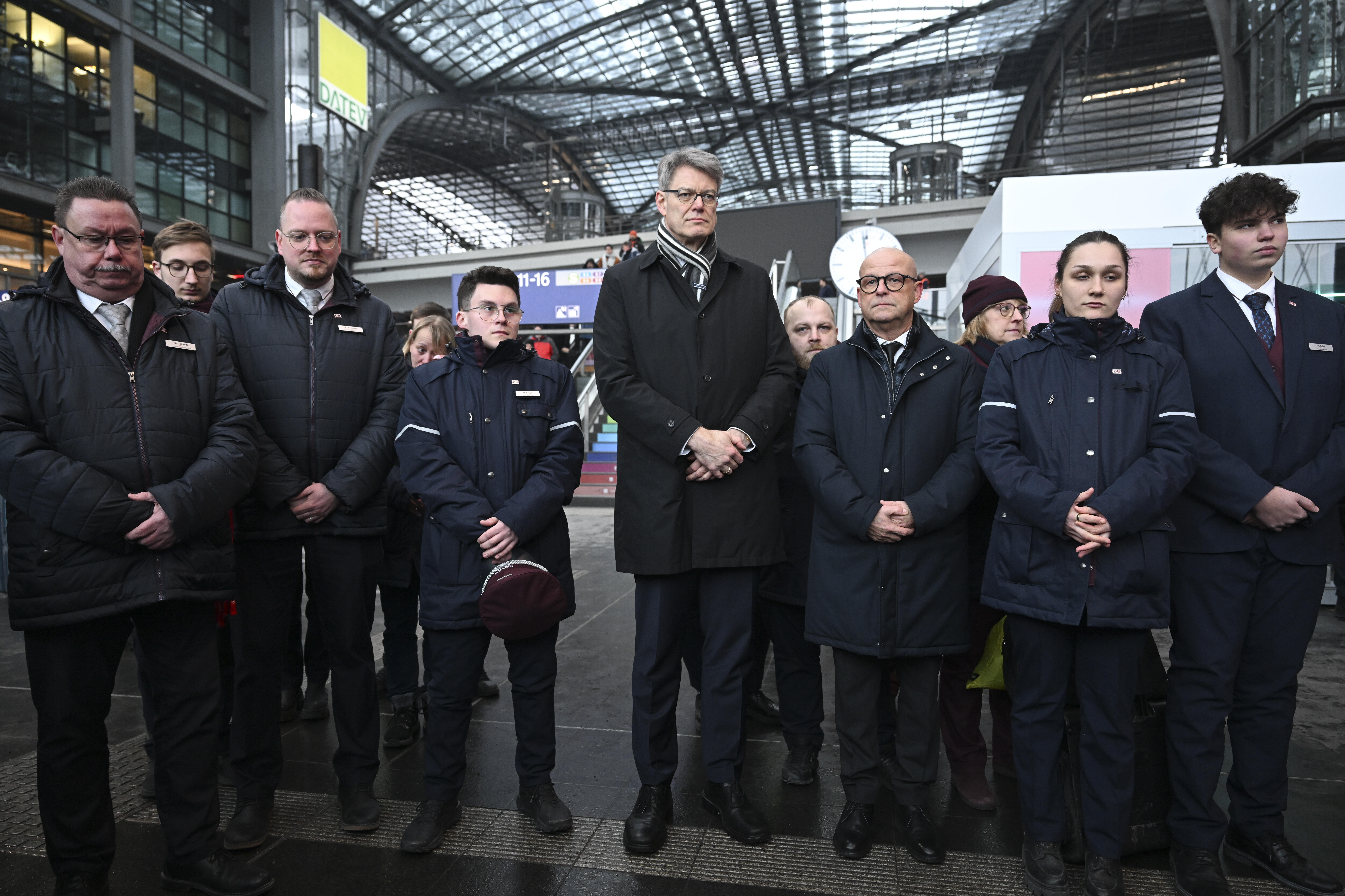 Bundesverkehrsminister Patrick Schnieder (M.) und Bahn-Mitarbeiter gedenken im Berliner Hauptbahnhof des 36-jährigen Zugbegleiters Serkan C.