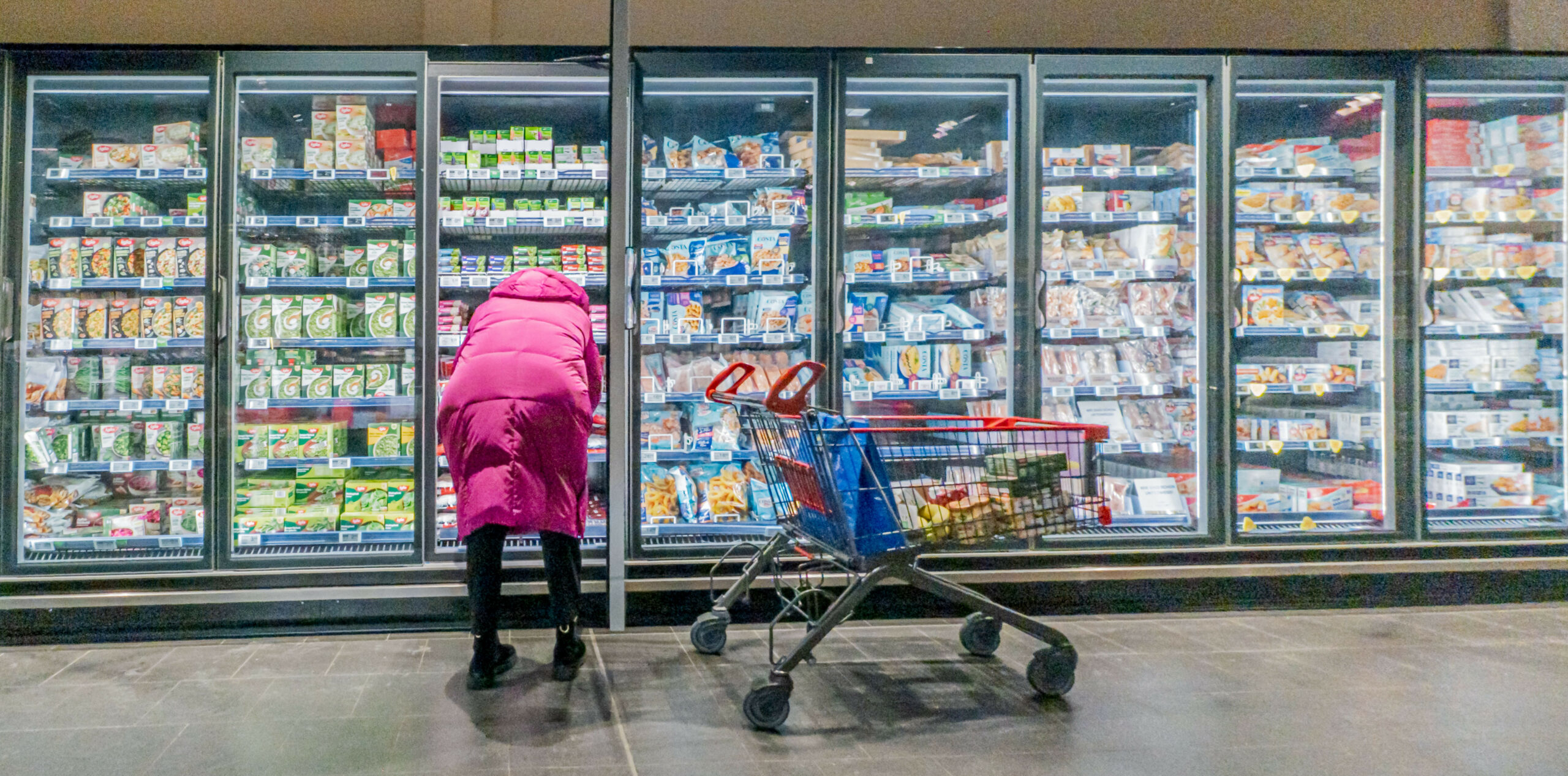 Eine Frau steht vor einem Lebensmittelregal.