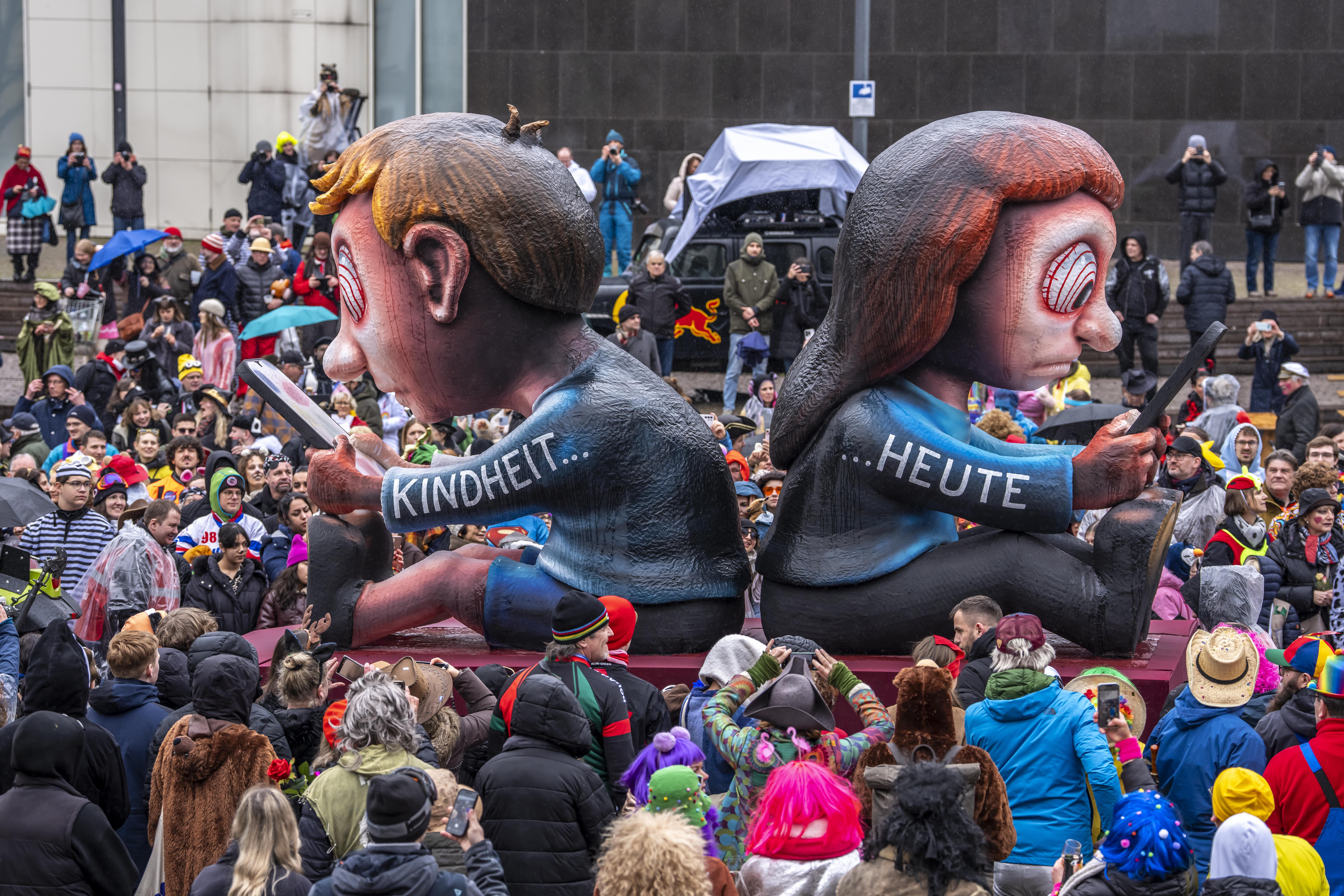 Ein Motto-Wagen auf dem Düsseldorfer Karnevals-Umzug nimmt das Thema Jugendliche und Social Media- und Handy-Nutzung aufs Korn.