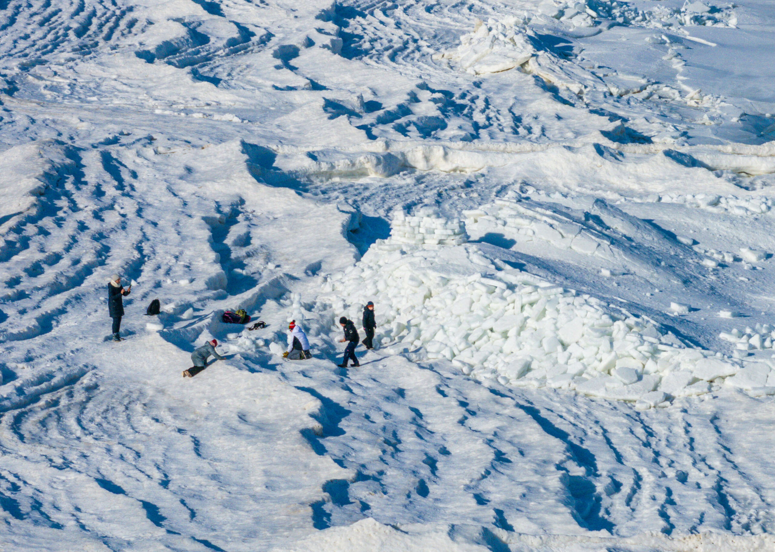 Urlauber klettern auf den meterhohen Eisbergen am Ostseestrand auf der Insel Usedom.
