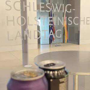 Zwei Getränkedosen stehen im Landtag vor dem Plenarsaal auf einem Tisch. Im Landtag wird über ein Verbot von Energydrinks für Jugendliche unter 16 Jahren debattiert.