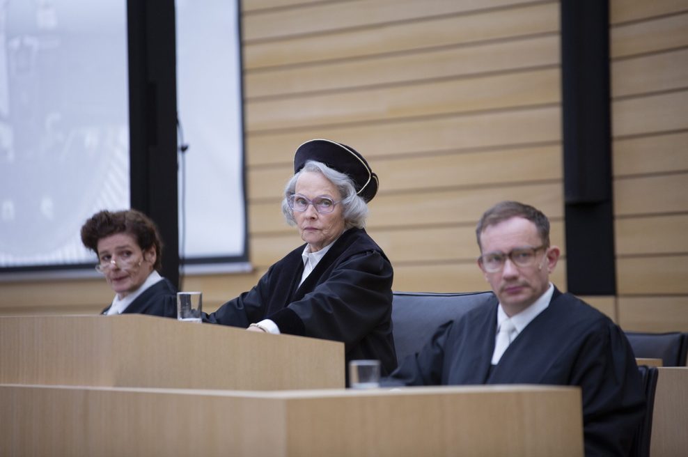 Situation im Gericht, man sieht drei Menschen