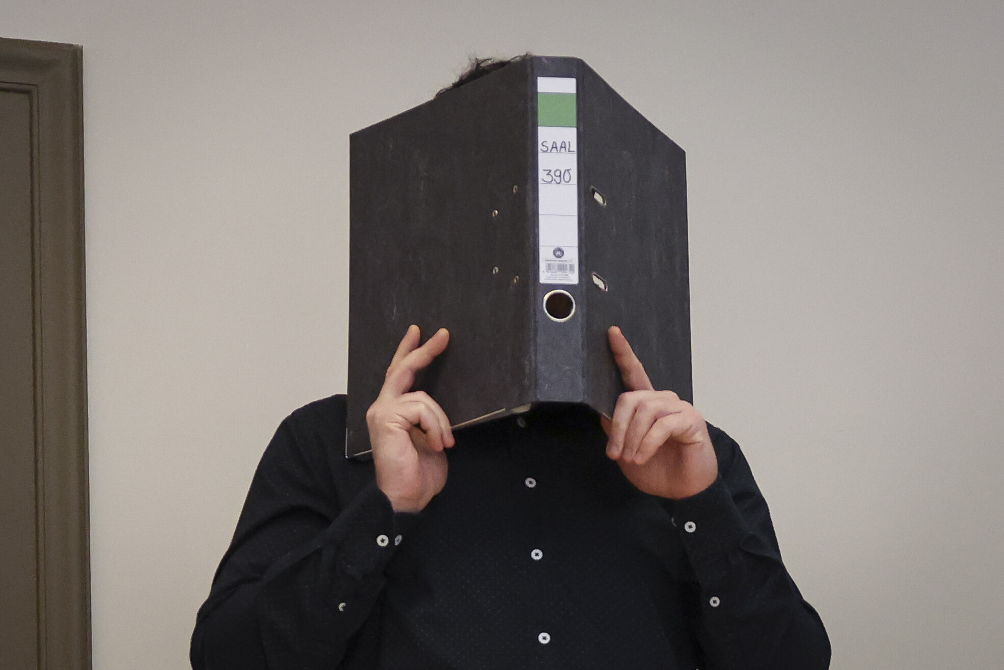 Prozess wegen Geiselnahme: Der Angeklagte Patrick G. (Name geändert) hält sich vor der Urteilsverkündung am Freitag im Hamburger Landgericht einen Aktenordner vors Gesicht.