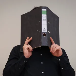 Prozess wegen Geiselnahme: Der Angeklagte Patrick G. (Name geändert) hält sich vor der Urteilsverkündung am Freitag im Hamburger Landgericht einen Aktenordner vors Gesicht.