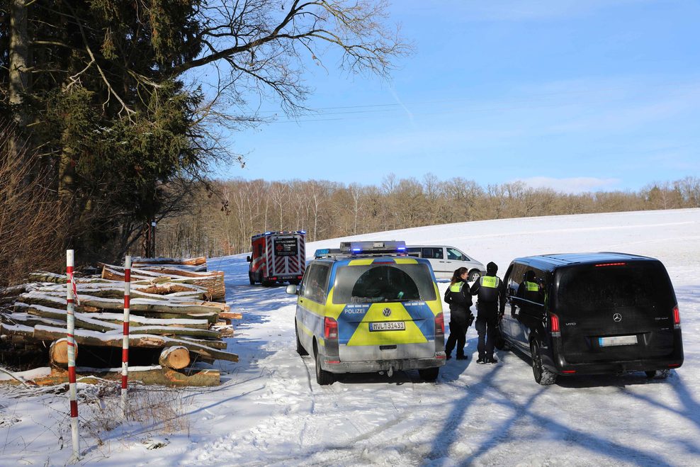 Polizeiwagen stehen auf dem Schnee. Im Hintergrund ist ein Rettungswagen zu sehen.