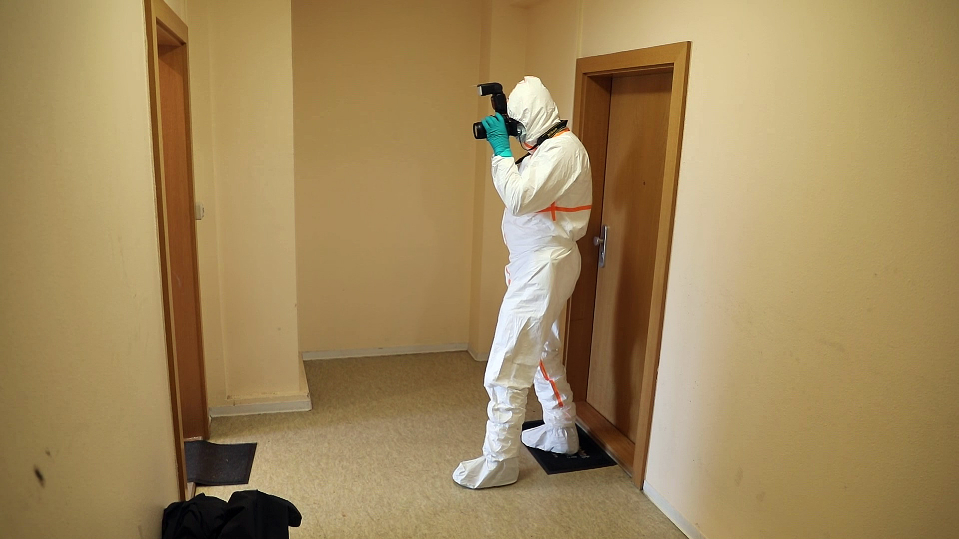 Ein Ermittler macht Fotos von dem Tatort in Rostock. Überall in der Wohnung war Blut.