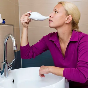 Eine Frau benutzt eine Nasendusche