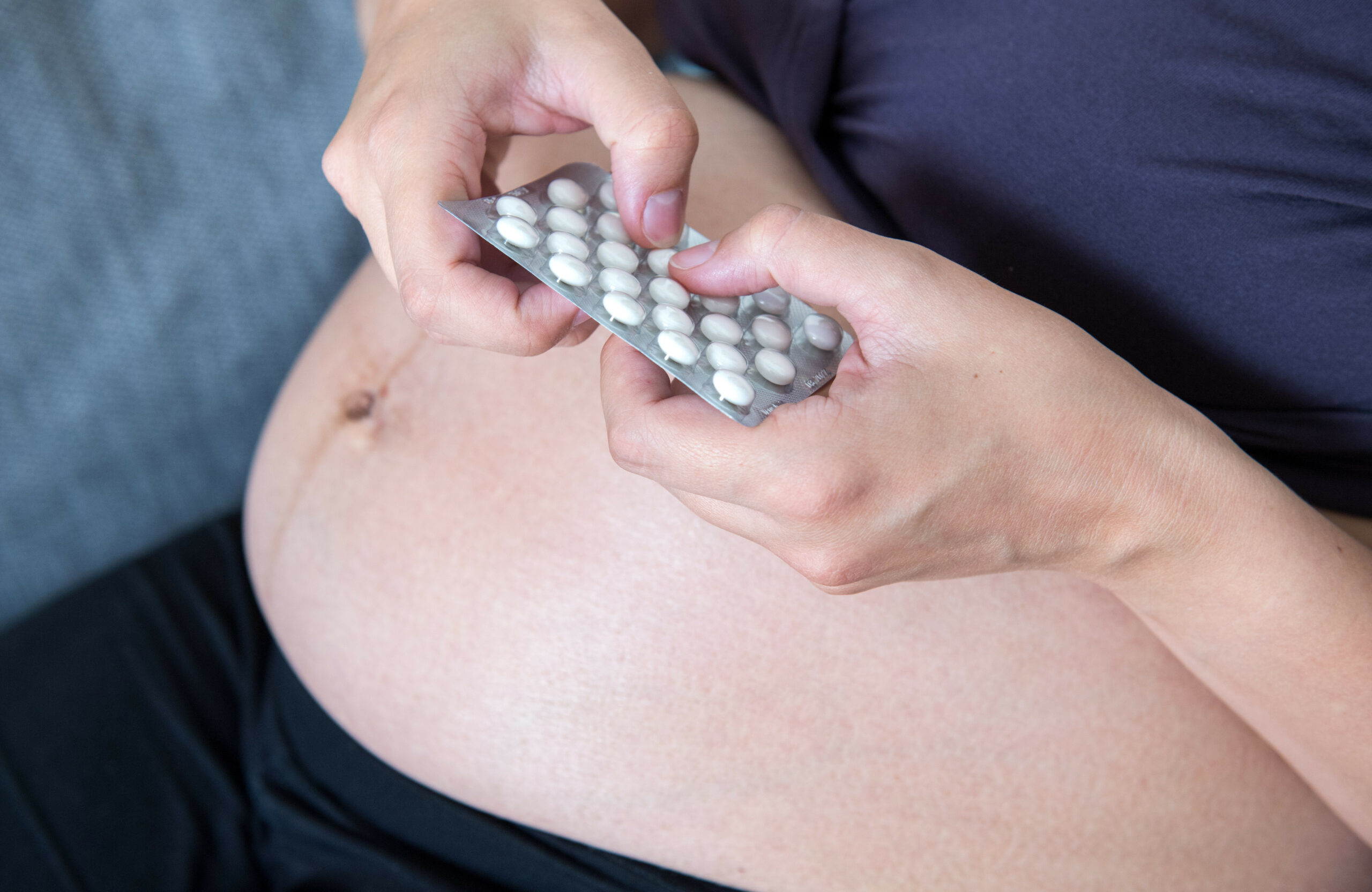 Eine schwangere Frau mit Tabletten