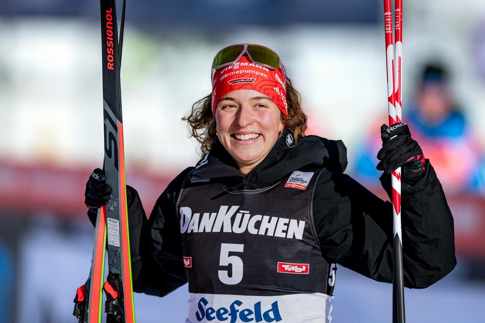 Nathalie Armbruster lächelt mit ihren Skiern in der Hand