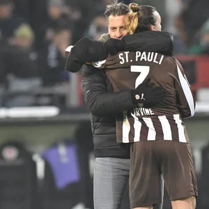 St. Pauli-Trainer Alexander Blessin umarmt Jackson Irvine