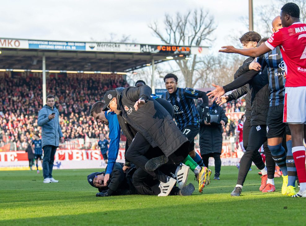 Cottbus-Trainer Claus-Dieter Wollitz bringt Mannheims Sportlichen Leiter Gerhard Zuber zu Fall