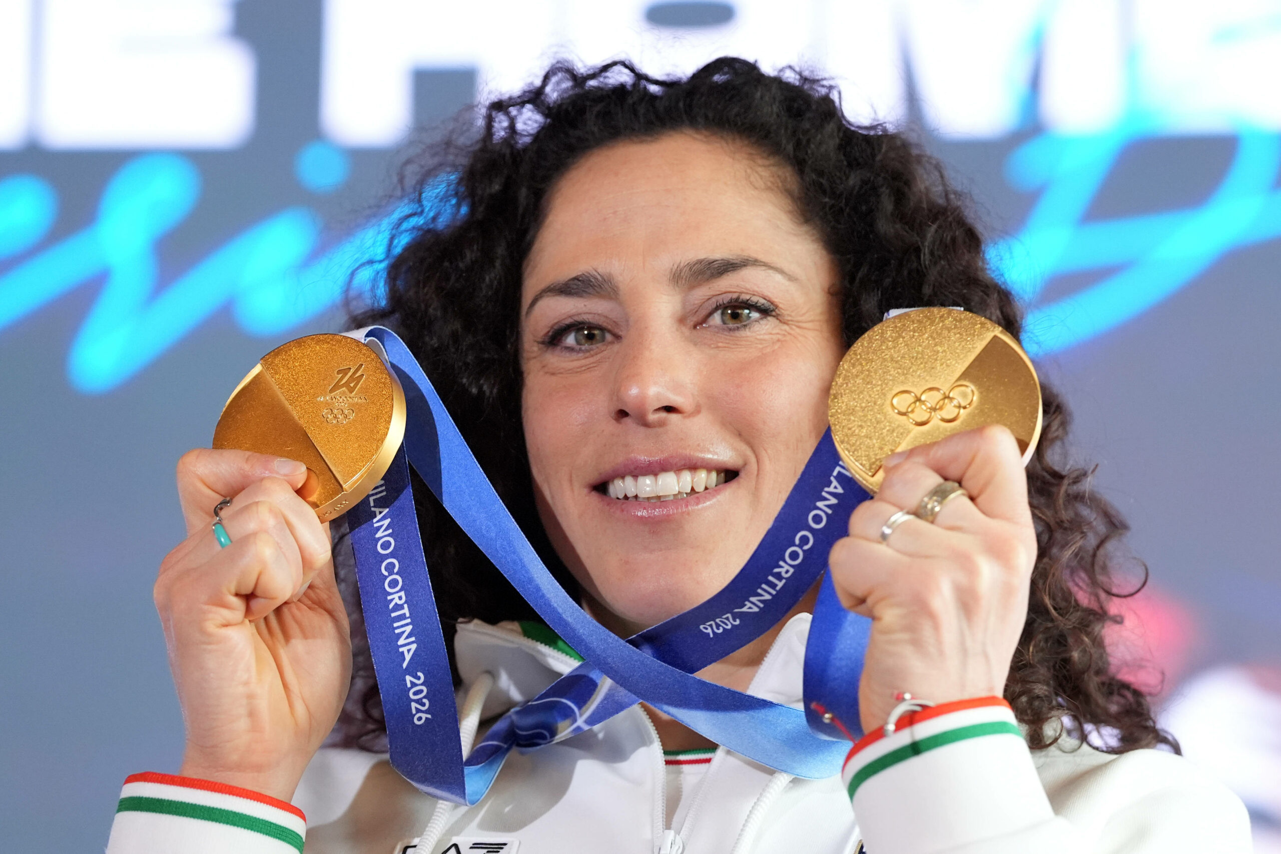 Federica Brignone zeigt ihre beiden Goldmedaillen und lächelt