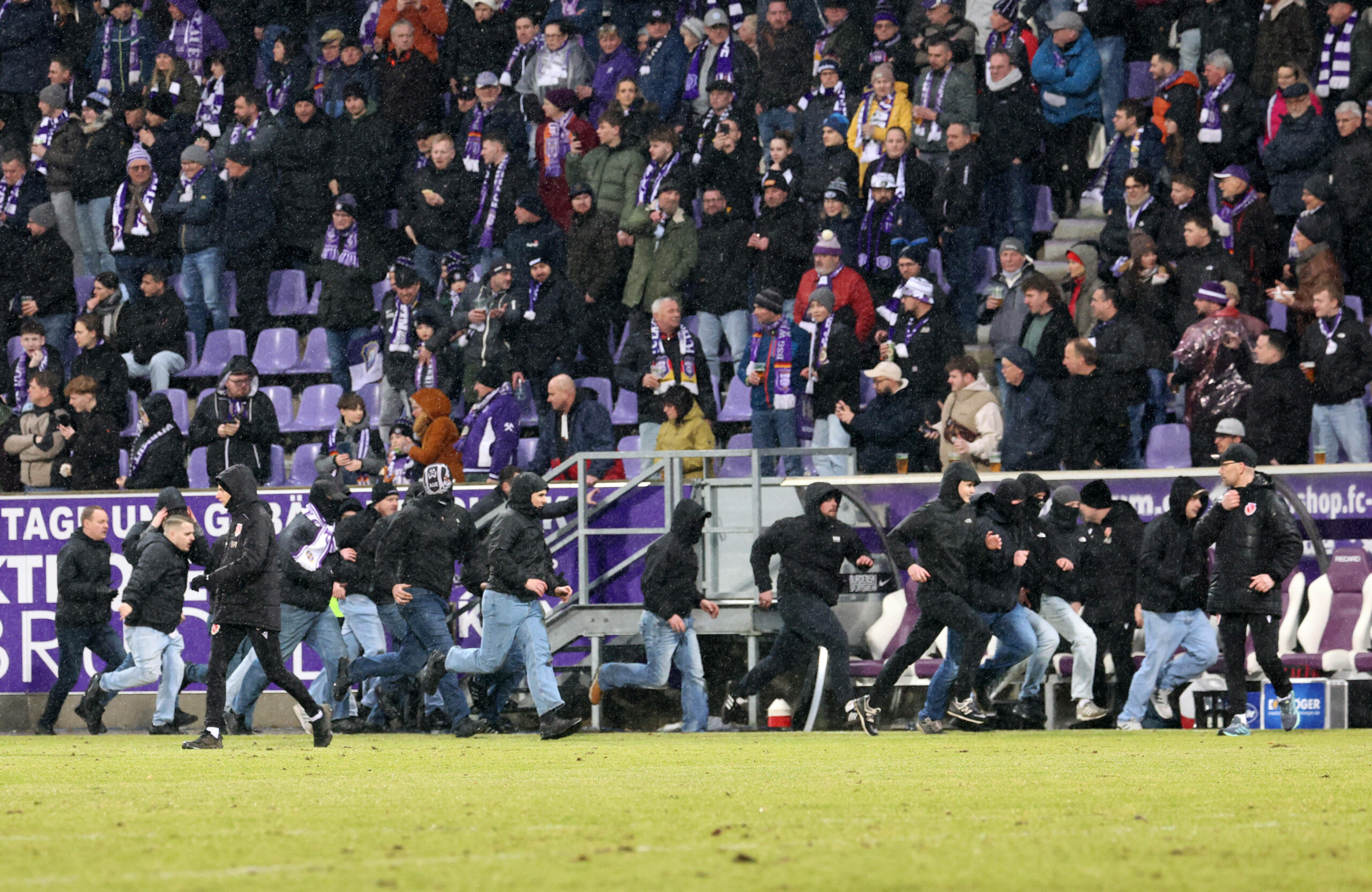 Fans von Erzgebirge Aue stürmen beim 3. Liga-Spiel gegen Cottbus auf den Platz