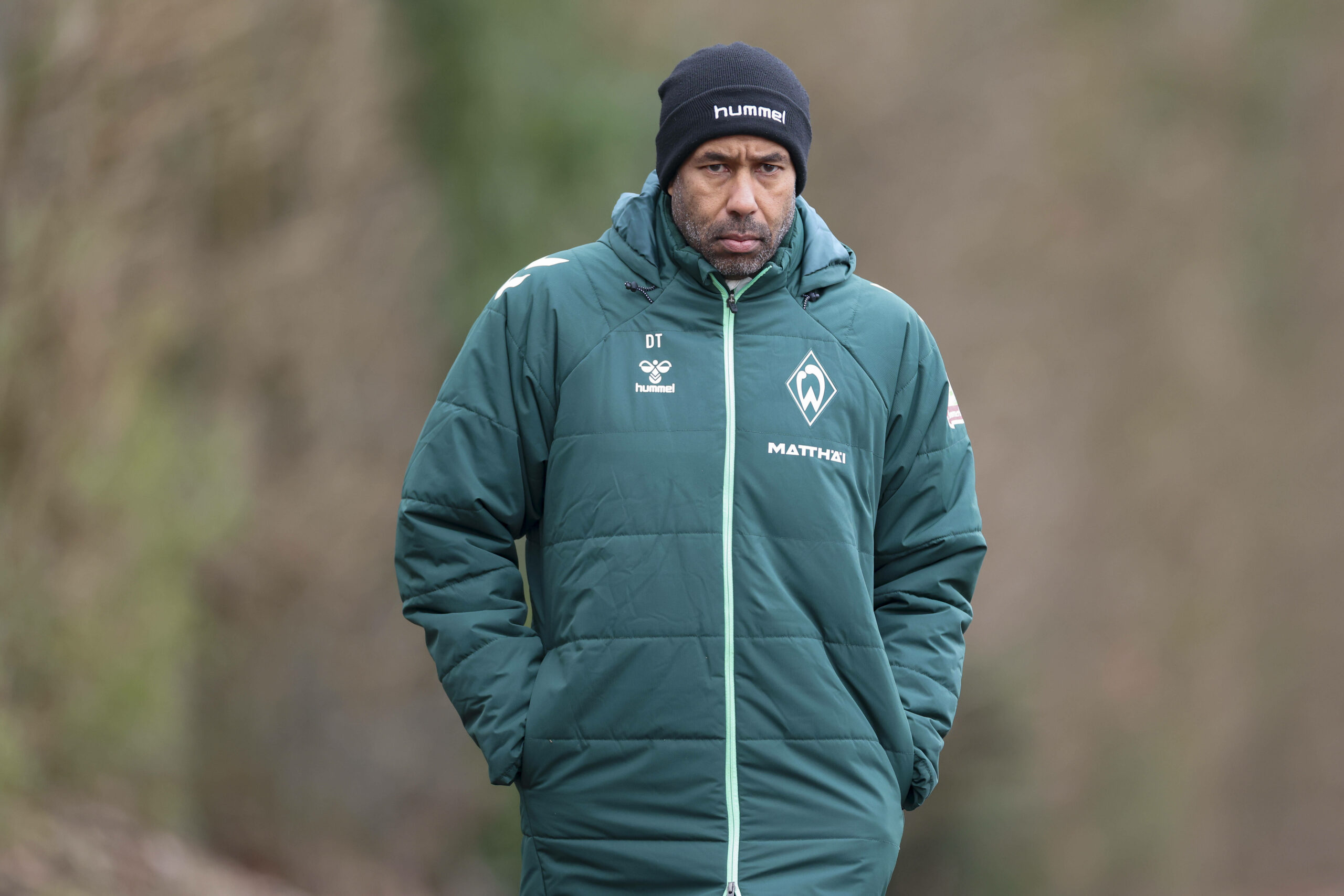 Daniel Thioune schaut konzentriert während er zum Trainingsplatz läuft