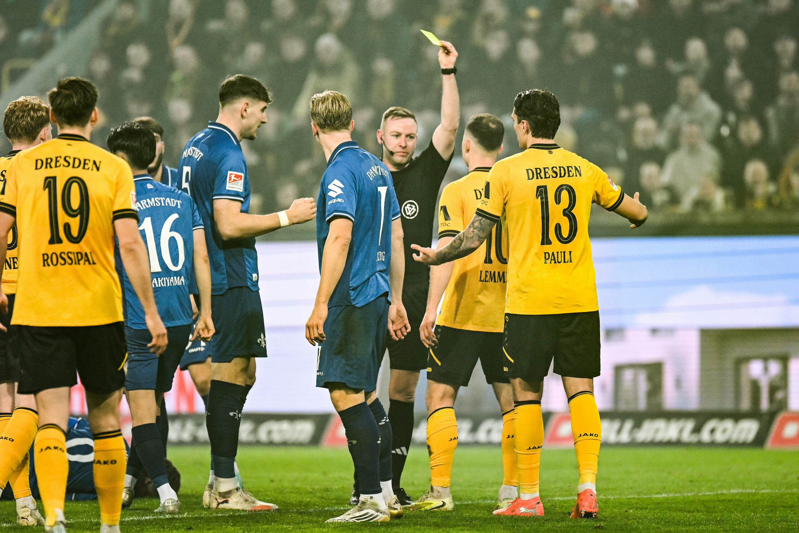Schiedsrichter Lars Erbst zeigt einem Dresden-Profi die Gelbe Karte
