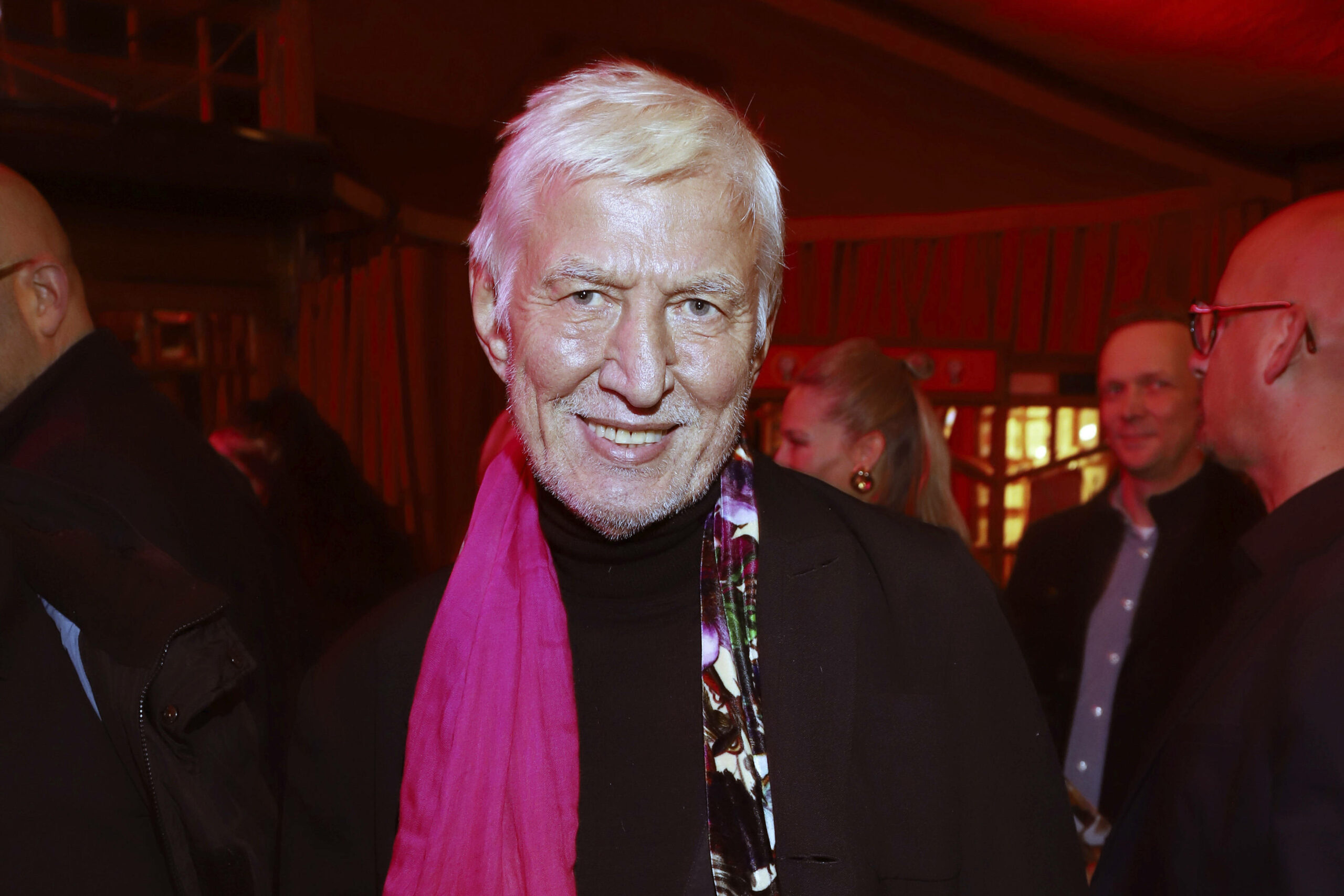 Ted Linow 2024 mit weißen Haaren und einem pinken Schal um den Hals.