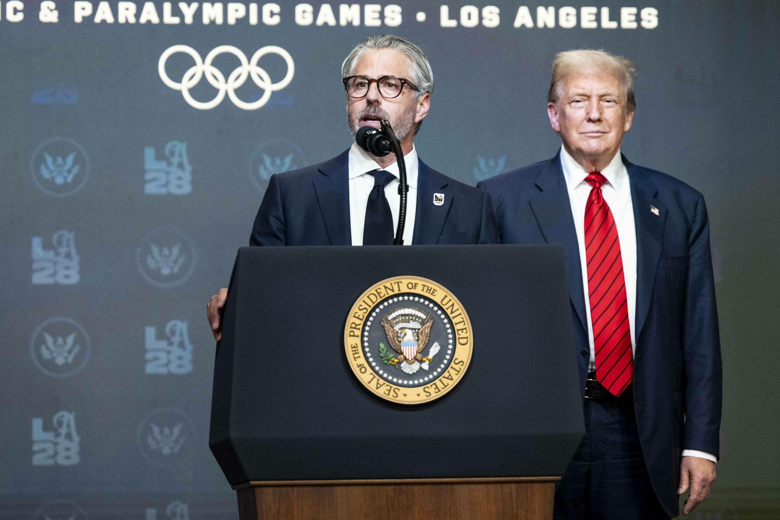 Casey Wasserman in einer Rede neben Donald Trump