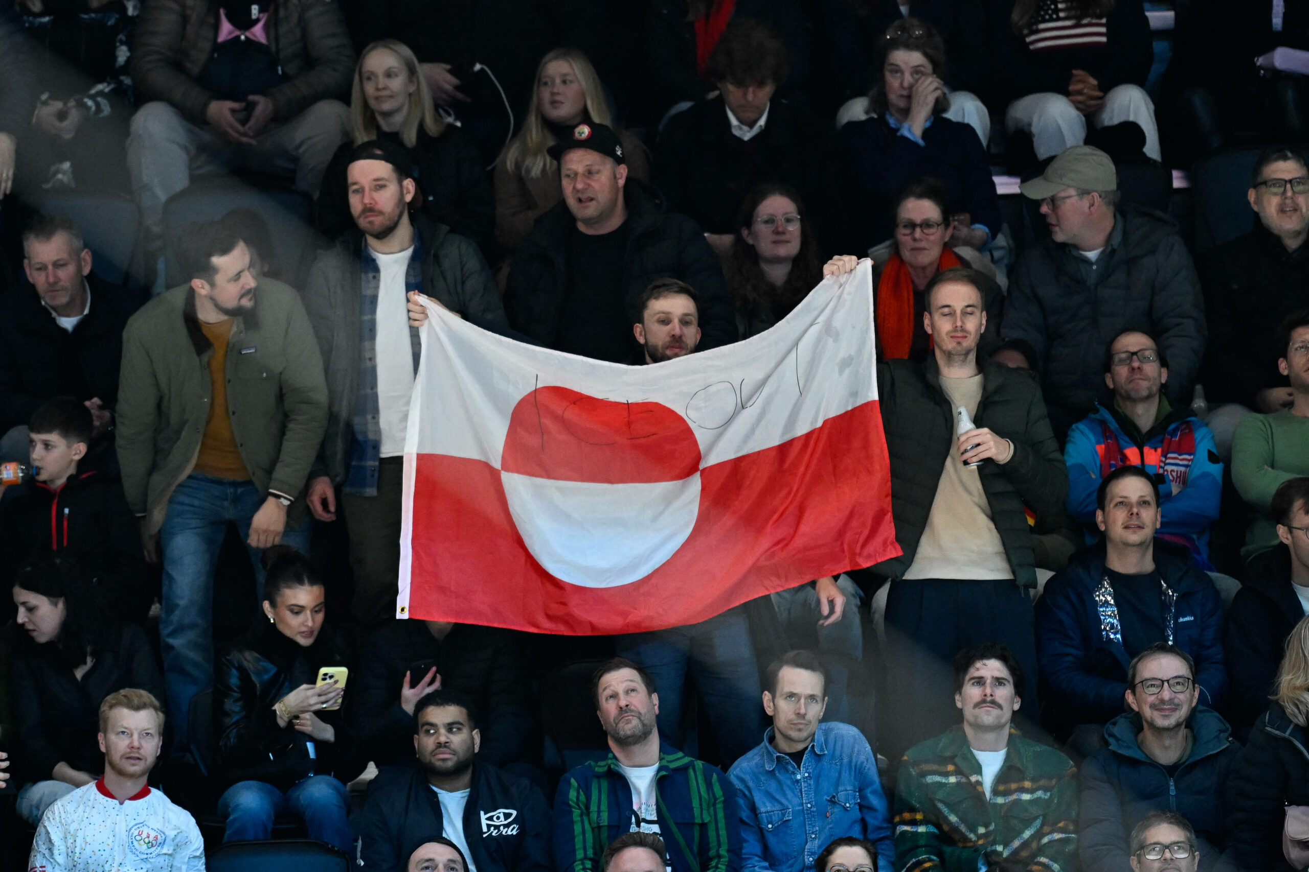 Lettische Curling-Fans aus Deutschland haben mit einer Grönland-Flagge bei einem Eishockeyspiel der USA während der Olympischen Winterspiele in Mailand