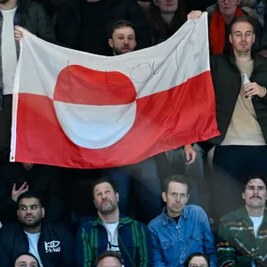 Lettische Curling-Fans aus Deutschland haben mit einer Grönland-Flagge bei einem Eishockeyspiel der USA während der Olympischen Winterspiele in Mailand
