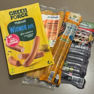 Vier Produkte pflanzlicher Würstchen.