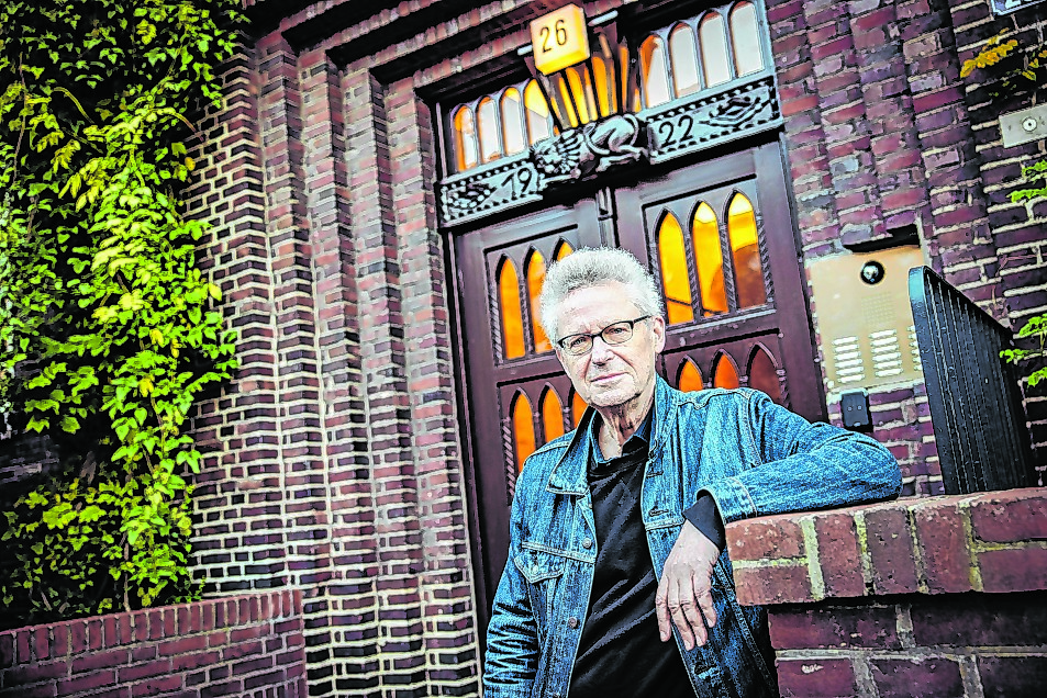 Michael Batz steht vor einer Tür und blickt in die Kamera