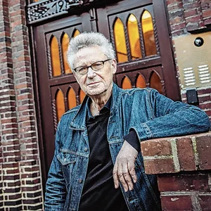 Michael Batz steht vor einer Tür und blickt in die Kamera