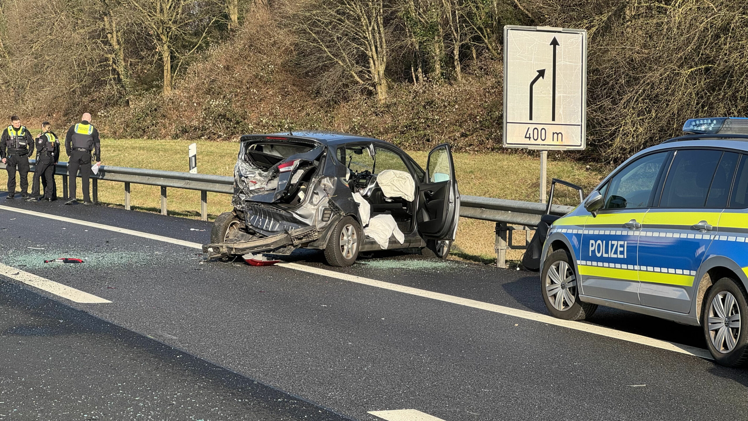 Ein völlig zerstörter Kleinwagen steht auf dem Seitenstreifen.