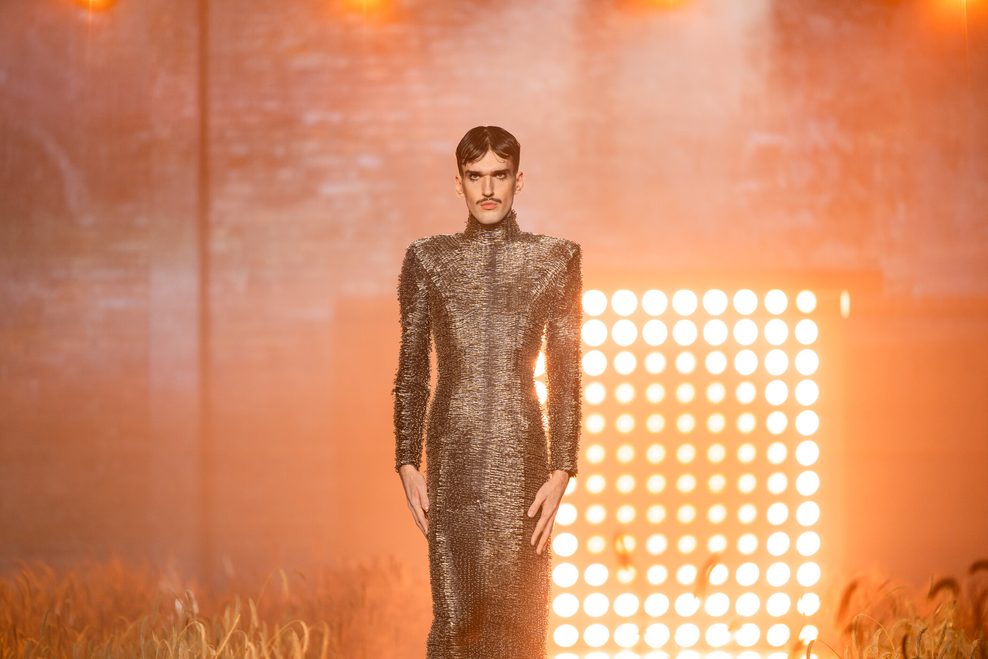 Kandidat Lukas (21) in einem langen engen Kleid aus Sicherheitsnadeln.