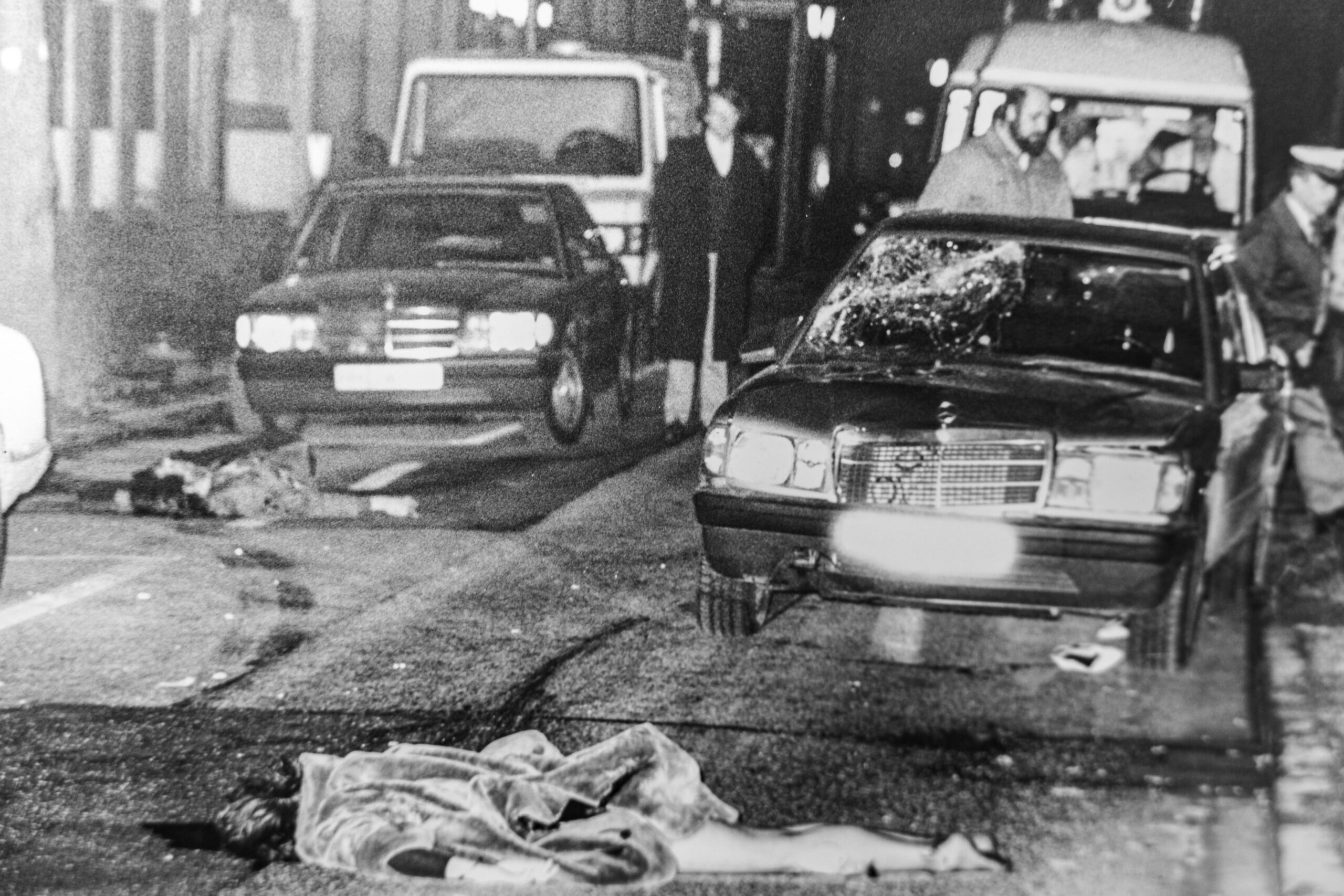 Die beiden toten Fußgänger liegen auf der Straße An der Alster. Sie waren von dem vorderen Mercedes 190 erfasst worden. Die Spuren des Aufpralls sind deutlich zu sehen.