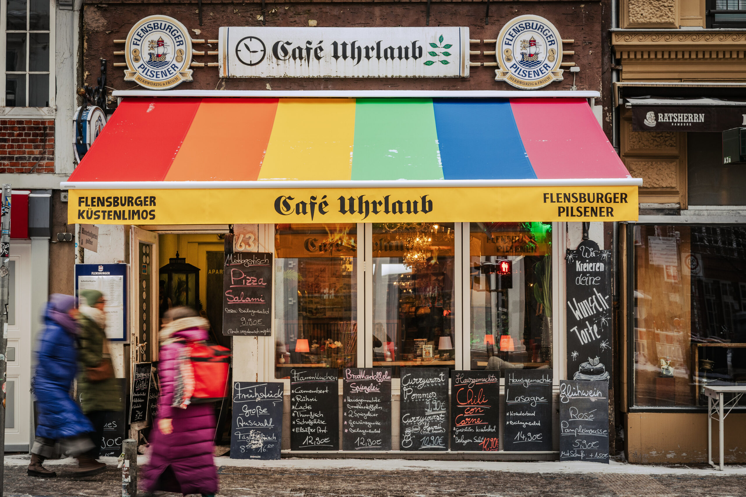 Die neue Markise des „Café Uhrlaub“ strahlt in Regenbogen-Farben.