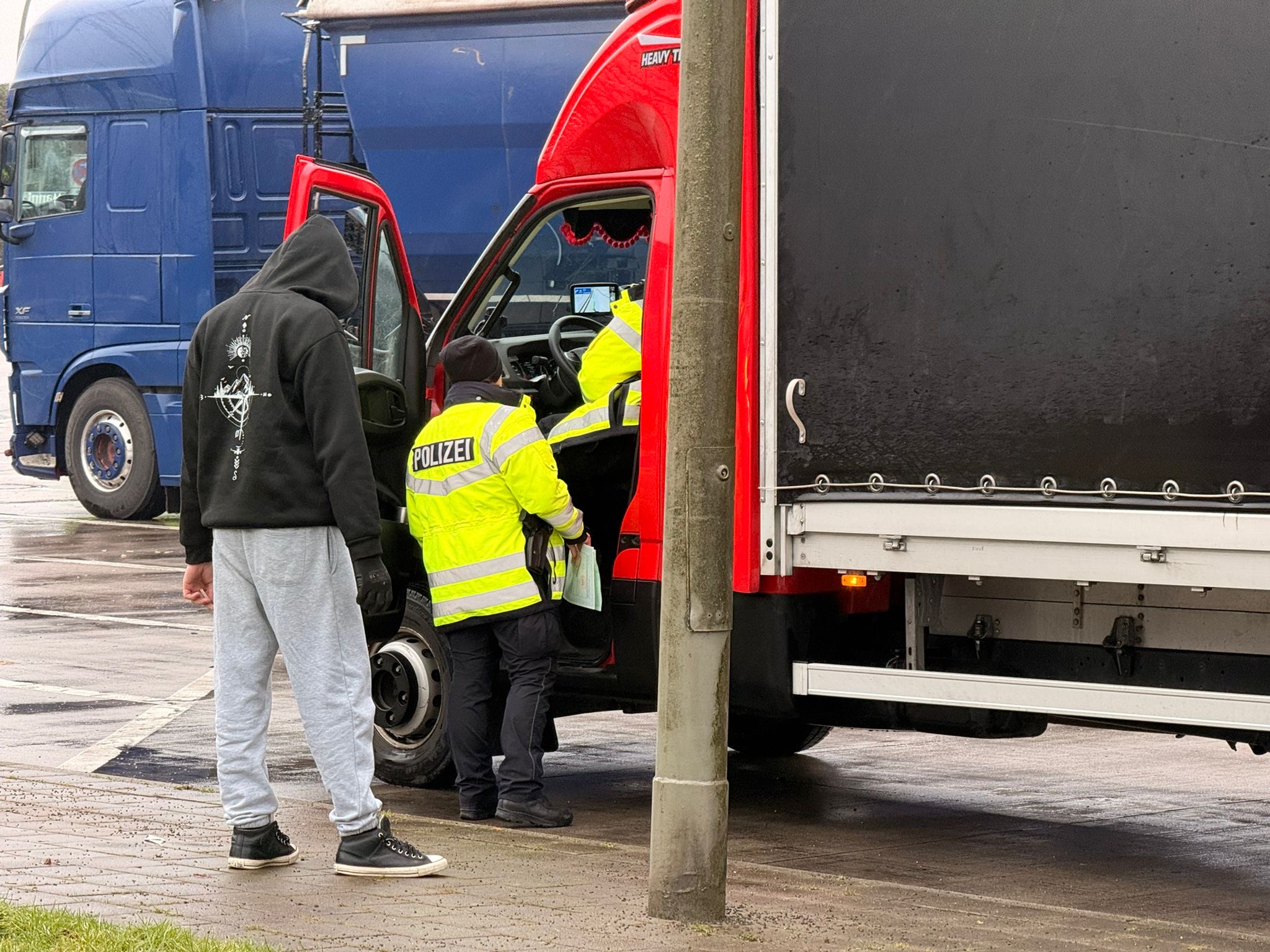 Ein Fahrer wird von Polizisten kontrolliert.