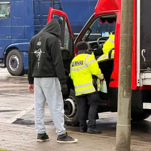 Ein Fahrer wird von Polizisten kontrolliert.