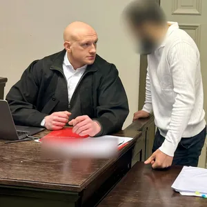 Der Angeklagte (r.), ein ehemaliger Kampfsportler, unterhält sich vor dem Prozess mit seinem Anwalt Noah Kistner.