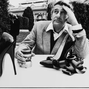 Fotografie eines Mannes, der an einem Tisch in einem Garten in Monte Carlo sitzt.